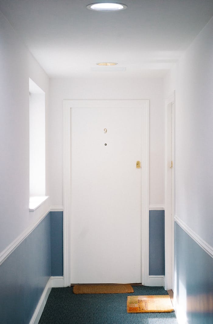 our-experience Bright minimalist hallway with door number 9 in a London apartment, capturing simple elegance.